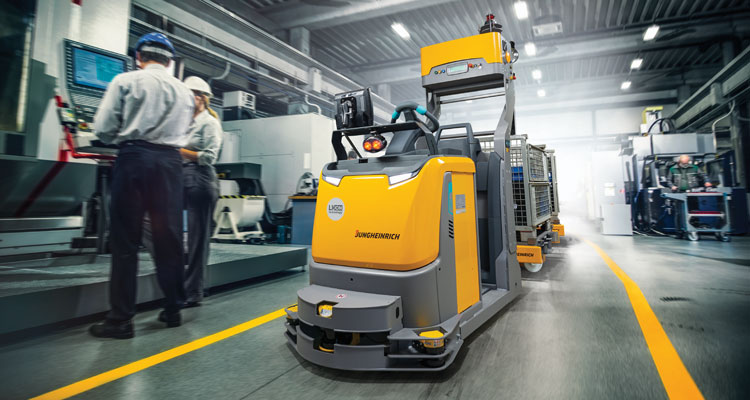 automated tugger forklift in warehouse with people